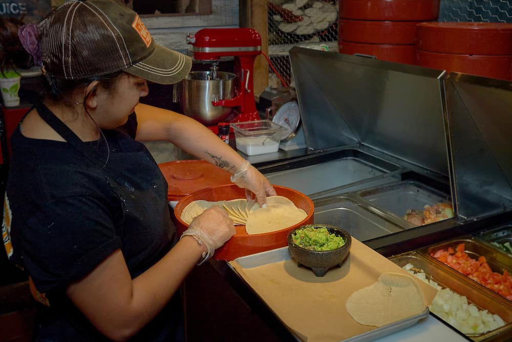 employee making fresh guacamole and tortillas at fort worth texas kitchen in sevierville